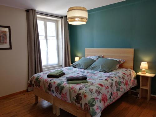 une chambre avec un grand lit aux murs bleus dans l'établissement Gîte Le Nid'Anges, à Putanges