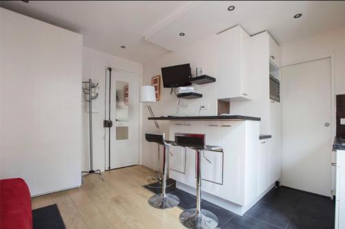 un salon avec des murs blancs et une cuisine avec un comptoir dans l'établissement Magnifique studio Cannes, à Cannes