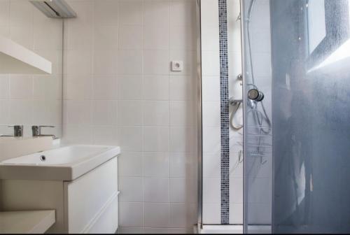 une salle de bain blanche avec une douche et un lavabo dans l'établissement Magnifique studio Cannes, à Cannes