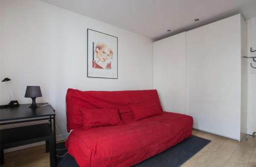 un canapé rouge dans un salon avec un bureau dans l'établissement Magnifique studio Cannes, à Cannes