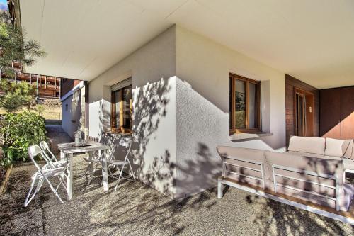 a patio with a bench and a table and chairs at Val Air E53 Terrace & Relaxation in Champéry