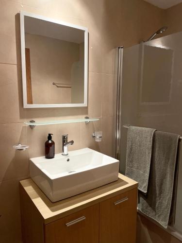 a bathroom with a sink and a mirror and towels at Pedro’s Apartment in Sucina