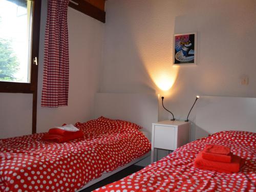 シャテルにあるChalet 6 pers à Châtel, proche centre et remontées, terrasse et équipements modernes - FR-1-676-135のベッド2台 赤いシーツ、窓が備わるドミトリールームです。