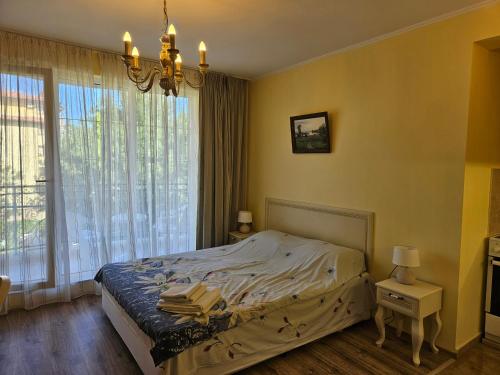 a bedroom with a bed and a large window at Apartments Anna on the Sunny beach in Sunny Beach