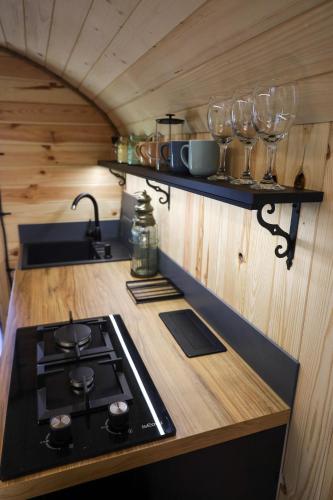 a kitchen with a stove and glasses on a counter at Oaza Święty Spokój - domek z balią i jacuzzi in Rząśnik