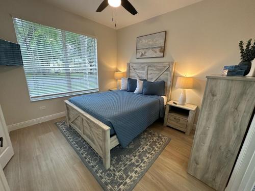 a bedroom with a bed with blue pillows and a window at South Facing Pool Villa Spa Remodeled Floor to Ceiling Southern Dunes in Haines City