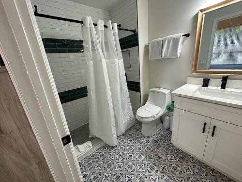 a bathroom with a shower and a toilet and a sink at South Facing Pool Villa Spa Remodeled Floor to Ceiling Southern Dunes in Haines City