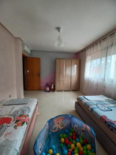 a room with two beds and a tub of balls at Ilyass Garden Beach Sidi Rahal in Dar Hamida