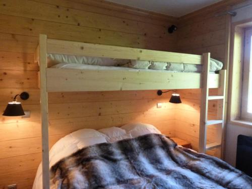 sypialnia z 2 łóżkami piętrowymi w drewnianej ścianie w obiekcie Résidence Le Vallon - Appartement 2 pièces pour 4-5 personnes situé à Méribel centre proche des commerces et des pistes de ski MAE-1766 w mieście Les Allues