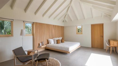 MarigotにあるExceptional 4BR Villa Overlooking the Oceanのベッドとテーブルと椅子のある寝室