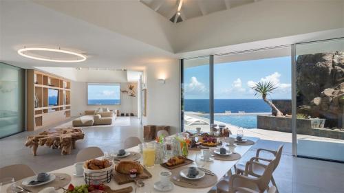MarigotにあるExceptional 4BR Villa Overlooking the Oceanのダイニングルーム(テーブル付)が備わり、海の景色を望めます。