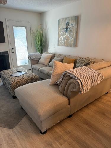 a living room with a couch and a ottoman at Selah in Saint Simons Island