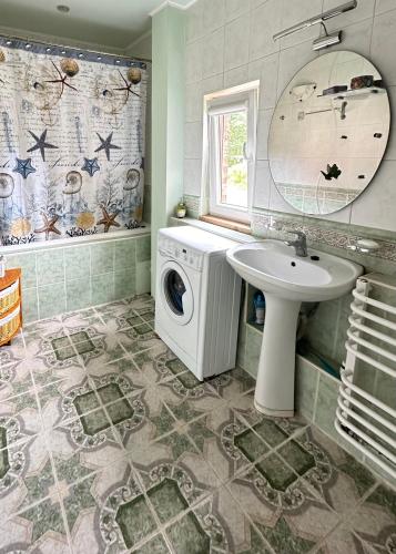 a bathroom with a washing machine and a sink at fantasy park in Ventspils