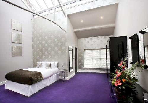 a bedroom with a large bed and purple carpet at Aston Hall Hotel, BW Signature Collection in Sheffield