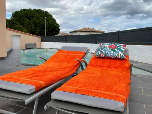two beds on a patio with a swimming pool at La Villa des Cistes au calme vue Étangs in Narbonne