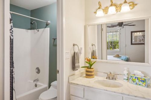 a bathroom with a sink and a mirror at Poipu Palms 302 in Koloa