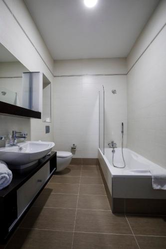 a bathroom with two sinks and a tub and a shower at 602 Sliema 3Bed seafront with Pool by Homely in Sliema