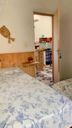 a bedroom with a blue and white bed and a kitchen at Casa em Mundaú Trairi-Ce in Trairi