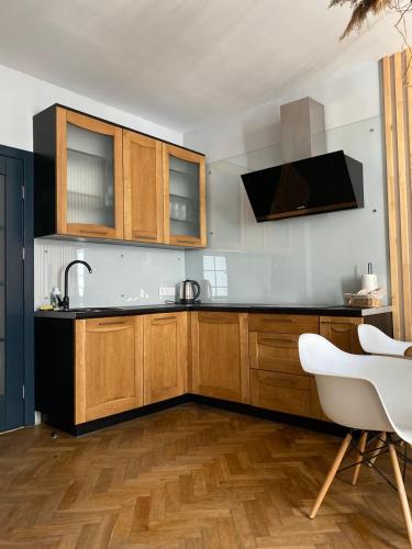 a kitchen with wooden cabinets and a sink at LvApart вул Ковжуна 2 кім ізол кухня студія звітні документи in Lviv