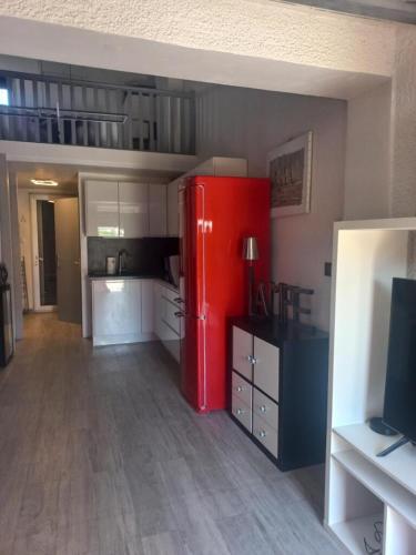 Cette chambre comprend une cuisine équipée d'un réfrigérateur rouge. dans l'établissement Villa Village Naturiste Cap d'Agde, au Cap d'Agde