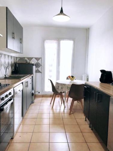 une cuisine avec une table et des chaises dans une pièce dans l'établissement Appartement vue sur mer La Joliette, à Marseille