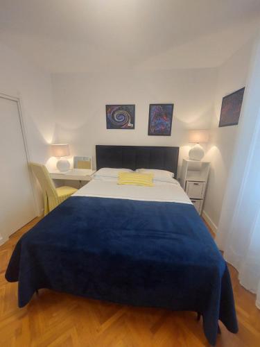 a bedroom with a large bed with a blue blanket at Vila DORA - Studio Dora in Martinšćica