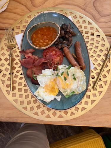 een bord ontbijtproducten met eieren, worst en bonen bij Cherubim Heights Villa in Johannesburg