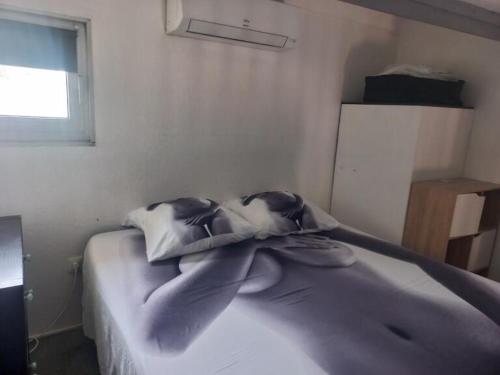 une chambre avec un lit avec une couverture dessus dans l'établissement Villa Village Naturiste Cap d'Agde, au Cap d'Agde