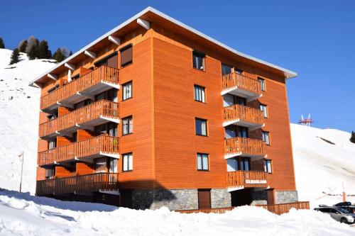un grand bâtiment dans la neige dans l'établissement Résidence Le Kilimandjaro - Grand Studio 3/4 pers - LE KILIMANDJARO - PLAGNE CENTRE MAE-1584, à Aime La Plagne