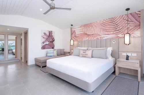 a bedroom with a large white bed and a couch at Royalton CHIC Antigua, An Autograph Collection All-Inclusive Resort - Adults Only in Saint Johnʼs