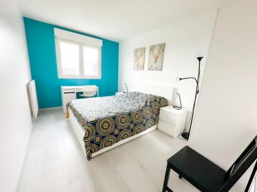 une chambre avec un lit et un mur bleu dans l'établissement Tiya-Gare Champs sur Marne-Parking Gratuit, à Champs-sur-Marne