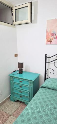 a bedroom with a blue dresser next to a bed at casa al mare kalispera in Marina di Mancaversa