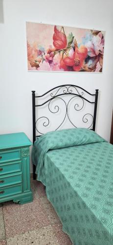 a bedroom with a bed and a painting on the wall at casa al mare kalispera in Marina di Mancaversa