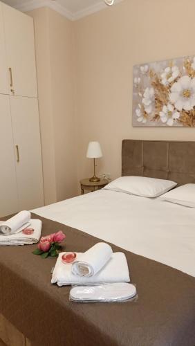 a bedroom with a bed with towels and flowers on it at Coolio's home in Ágios Rókkos