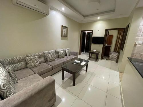 a living room with a couch and a table at شقق ربيع الخزمى للشقق المخدومة rabie alkhozama for serviced apartmentp in Al Khobar