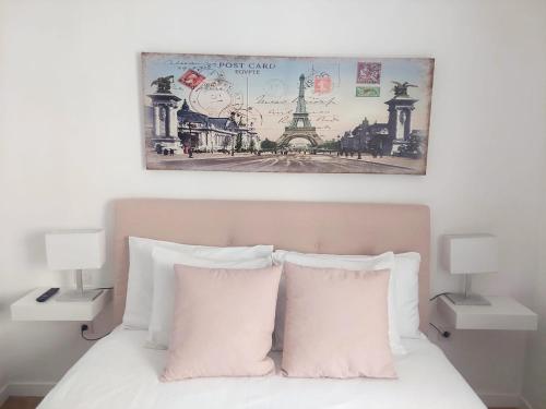 a bed with two white pillows and a picture above it at Agradable casa con terraza in Las Lagunas