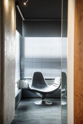a white chair in a room with a window at Hôtel Alt Quartier DIX30 in Brossard