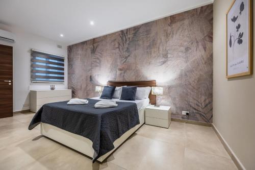 una camera da letto con un letto grande con cuscini blu di Fl 2 Thelodge-charming City Retreat By Homely a Mellieħa