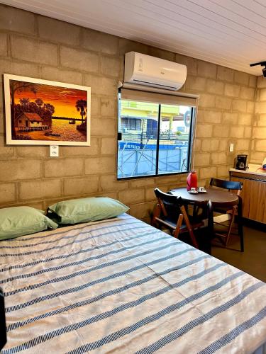 a bedroom with a bed and a table and a window at Apto Studio Industrial 07 in Manaus