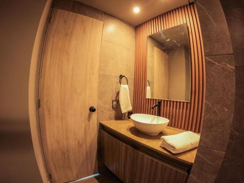 a bathroom with a sink and a mirror at Santorini Apartamentos Amoblados in Pereira