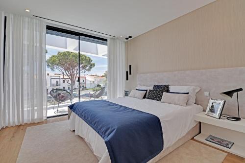 a bedroom with a large bed and a large window at One Six Villa in Vilamoura
