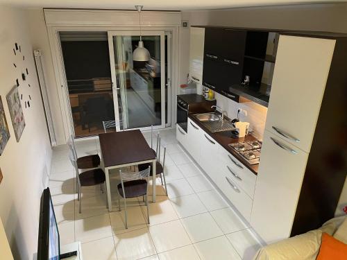 una cucina con tavolino, tavolo e sedie di DUPLEX LUXURY - MARINA SVEVA a San Salvo
