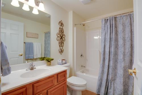 a bathroom with a sink and a toilet and a tub at Lake Views and Pool Access Osage Beach Condo in Osage Beach