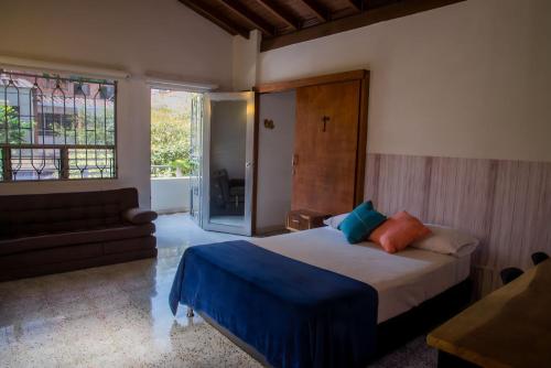 a bedroom with a bed and a couch and a window at CASA DE LOLA in Medellín