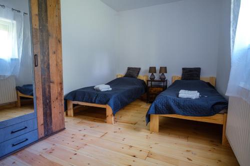 a bedroom with two beds and a mirror at Alpakavendégház in Balatoncsicsó