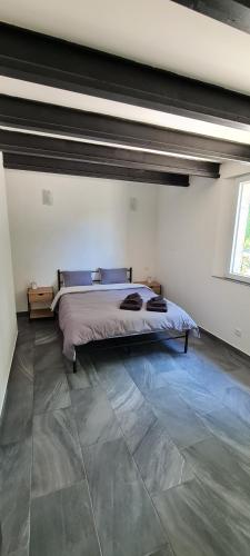 - une chambre avec un lit dans un dortoir doté de carrelage dans l'établissement Gîte de charme, à Firmi
