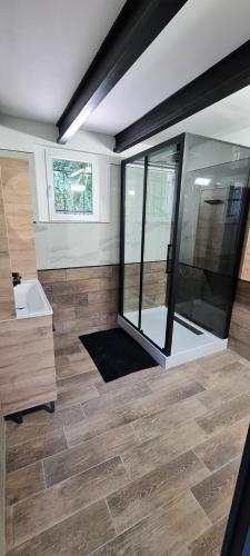 une chambre avec une grande douche en verre avec un lavabo dans l'établissement Gîte de charme, à Firmi