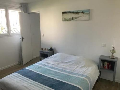 une chambre avec un lit et un tableau au mur dans l'établissement Appartement charmant aux Sables-d'Olonne avec terrasse., à Les Sables-dʼOlonne