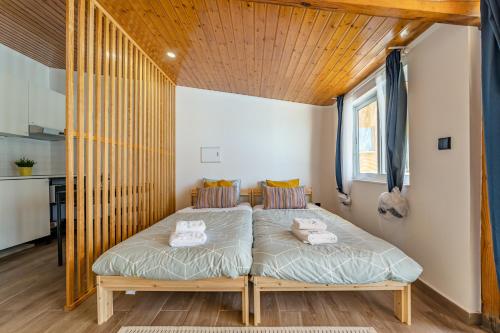 拉夫拉Wake up with the Sea Breeze- House with pool AP2的一间卧室，床上有两条毛巾