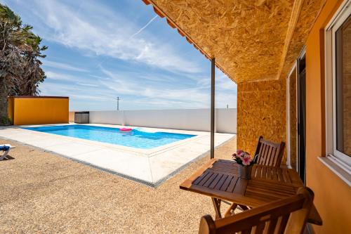 a swimming pool on a patio with a table and chairs at Wake up with the Sea Breeze- House with pool AP2 in Lavra